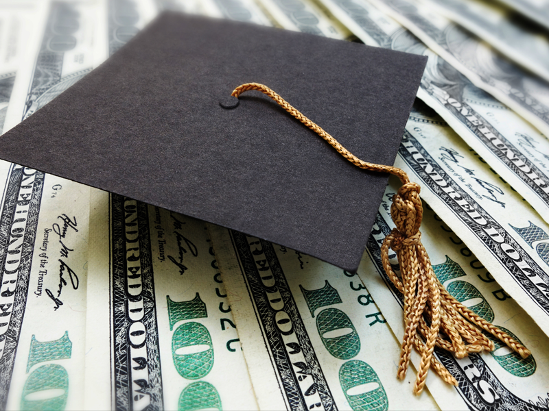 Graduation cap on top of money. Photo credit: Getty Images